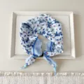 Detailed close-up of blue and white floral neck scarf with delicate botanical print and beads. - Two-tone Berry Leaf White