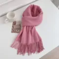 Close-up of pink imitation cashmere tassel scarf, cozy winter accessory on white surface. - Lotus Pink