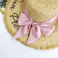 Schicker Strohsonnenhut mit rosa Schleife und schwarzer Stickerei, perfekt für Sommerstrände. - Rosa
