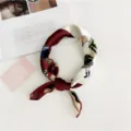 Close-up detail of the elegant red and white silk scarf with retro cartoon girl print. - Red & White Cartoon