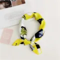 Elegant silk neck scarf detail shot, featuring a chic yellow and black designer pattern. - Yellow White Cartoon