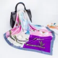 Detailed view of square silk scarf featuring vibrant floral and bamboo print with elegant border. - D9025-Purple