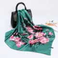Detailed view of a green satin silk scarf featuring vibrant pink floral print draped on a chic black bag. - D9022-Green