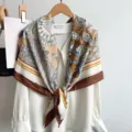 Detailed view of retro geometric silk feel square scarf with floral print and brown border. - Coffee