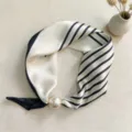 Close-up detail of black and white striped silk scarf with elegant pearl magnetic buckle. - CXK005-White Stripes