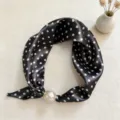 Close-up detail of a black polka dot silk scarf with an elegant pearl magnetic buckle. - CXK006-Small Polka Dots Black