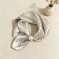Chic black and white geometric silk scarf with elegant pearl magnetic clasp detail. - Black and White X