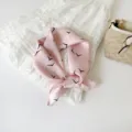 Detailopname van roze zijden sjaal met vogelmotief, ideaal als stijlvolle halsdoek en accessoire. - Roze