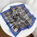 Detailed view of a stylish cotton square scarf featuring a classic plaid pattern and blue border. - Coffee Plaid