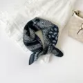Detailweergave van een chique zwart-witte paisley print zijdezachte vierkante sjaal voor dames. - Zwart