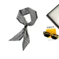Detail view of a chic black and white striped skinny scarf featuring an elegant bead fastener. - Thin Stripe Black