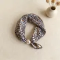 Vista detallada del pañuelo de seda con estampado de leopardo y su elegante hebilla magnética de perlas. - CXK006 - Estampado de leopardo con puntos amarillos