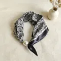 Detalle en primer plano del pañuelo de seda paisley en blanco y negro con cierre magnético perla. - CXK005-Paisley negro