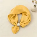 Vista dettagliata del foulard in seta con consistenza satinata liscia e fibbia magnetica. - Giallo Tinta Unita