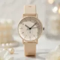 Nahaufnahme der minimalistischen cremefarbenen Uhr mit Silikonarmband und arabischen Ziffern. - Beige