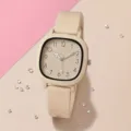 Hochauflösende Detailansicht einer beigen quadratischen Analoguhr mit weichem Silikonarmband - Khaki