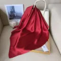 Detail shot of smooth red silk square scarf, elegant drape and glossy texture for women. - Burgundy