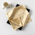Detailansicht des beigen Seidensatin-Quadrattuchs mit eleganten schwarzen Vögeln. - Gelber Vogel