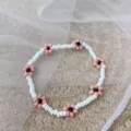 Braccialetto fatto a mano di perline bianche con graziosi ciondoli a margherita rosa. - bianco-rosa