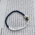 Primo piano braccialetto margherite di perline bianco nero, dettaglio di gioielli floreali. - Bianco e nero