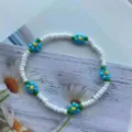 Primo piano dettagliato di un vivace braccialetto di margherite di perline con fiori. - bianco e blu