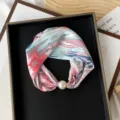 Close-up detail of a floral printed silk neck scarf with an elegant pearl magnetic buckle. - PC3683-Mountain Flowers in Bloom