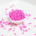 Gros plan détaillé de vermicelles cylindriques en pâte polymère rose vif pour décoration DIY - Pack de 100g / Rose rouge