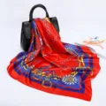 Detail view of red square satin silk scarf with elegant chain and baroque equestrian print. - D9031-Red
