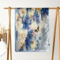 Detail view of a floral print silk scarf hanging on a wooden rack, elegant and soft. - Wealthy Peony