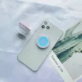 Detailaufnahme eines pastellfarbenen, ausziehbaren Handy-Griffs an einem Smartphone - Halterung mit Weißer Basis / Blau