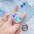 Close-up van een kleurrijke telefoonhouder met zeethema op een lichtblauwe smartphone - Zeewezen (1.8) / 1.8