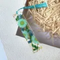 Close-up of handmade resin bookmark featuring real blue dried flowers and gold foil flakes. - Blue (5)