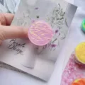 Nahaufnahme des lila schillernden, faltigen runden Handy-Griffs mit glänzender Textur - Laser Rundgriffständer / Rosa
