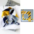Detailed view of stylish geometric silk square scarf with vibrant yellow and blue color block design. - Yellow and Blue Geometric