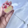 Close-up detail of a strawberry basket acrylic glitter badge reel showing retractable cord - Strawberry Basket