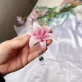 Primer plano de un porta credencial retráctil con forma de flor de lirio de acrílico rosa. - Rosa Blanco