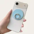 Soporte de anillo magnético azul claro en un smartphone blanco, sostenido en una mano - Soporte Magnético / Azul