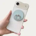 Detalle de un soporte magnético para anillo de color azul mate en un smartphone blanco - Soporte Magnético / Azul claro