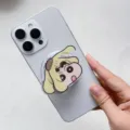 Gros plan d'un support de téléphone rotatif en acrylique avec un joli motif Crayon Shin-chan. - Support Magnétique / Purin Shin-chan Rotatif