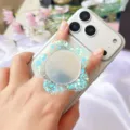 Nahaufnahme eines blumenförmigen Acryl-Handyhalters mit Glitzer und integriertem Spiegel - Erweiterbarer Ständer / Blau