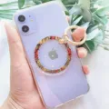 Detailansicht eines magnetischen Telefonringhalters mit Schlangenmuster auf einem lila iPhone - Orangegelb Schlangenmuster