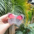Close-up of a pink butterfly acrylic phone grip stand held in hand outdoors - Expanding Stand / Red Butterfly
