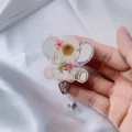 Close-up detail of a cute elephant badge reel featuring real dried flowers embedded in resin. - White Chrysanthemum Elephant Badge Reel