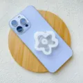 Acrylic flower-shaped collapsible phone grip stand attached to light blue smartphone - Support / Small White Flower