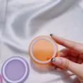 Primer plano de un adaptador de anillo magnético MagSafe naranja sobre seda blanca. - Disco Magnético / Naranja