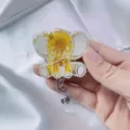 Close-up detail of cartoon elephant retractable badge reel with real dried flowers in resin - Yellow Chrysanthemum Elephant Badge Reel