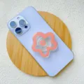 Close-up of peach flower acrylic collapsible phone grip on light blue smartphone - Support / Pink Flower