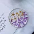 Macro detail view of clear resin coaster with purple stones, starfish and gold foil - Purple Ocean Round Coaster