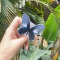 Close-up of a dreamy blue butterfly acrylic folding air cushion phone stand in hand - Expanding Stand / Black Butterfly
