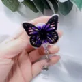 Close-up detail of butterfly resin badge reel with purple dried flowers and gold foil. - Black Butterfly Purple Flower